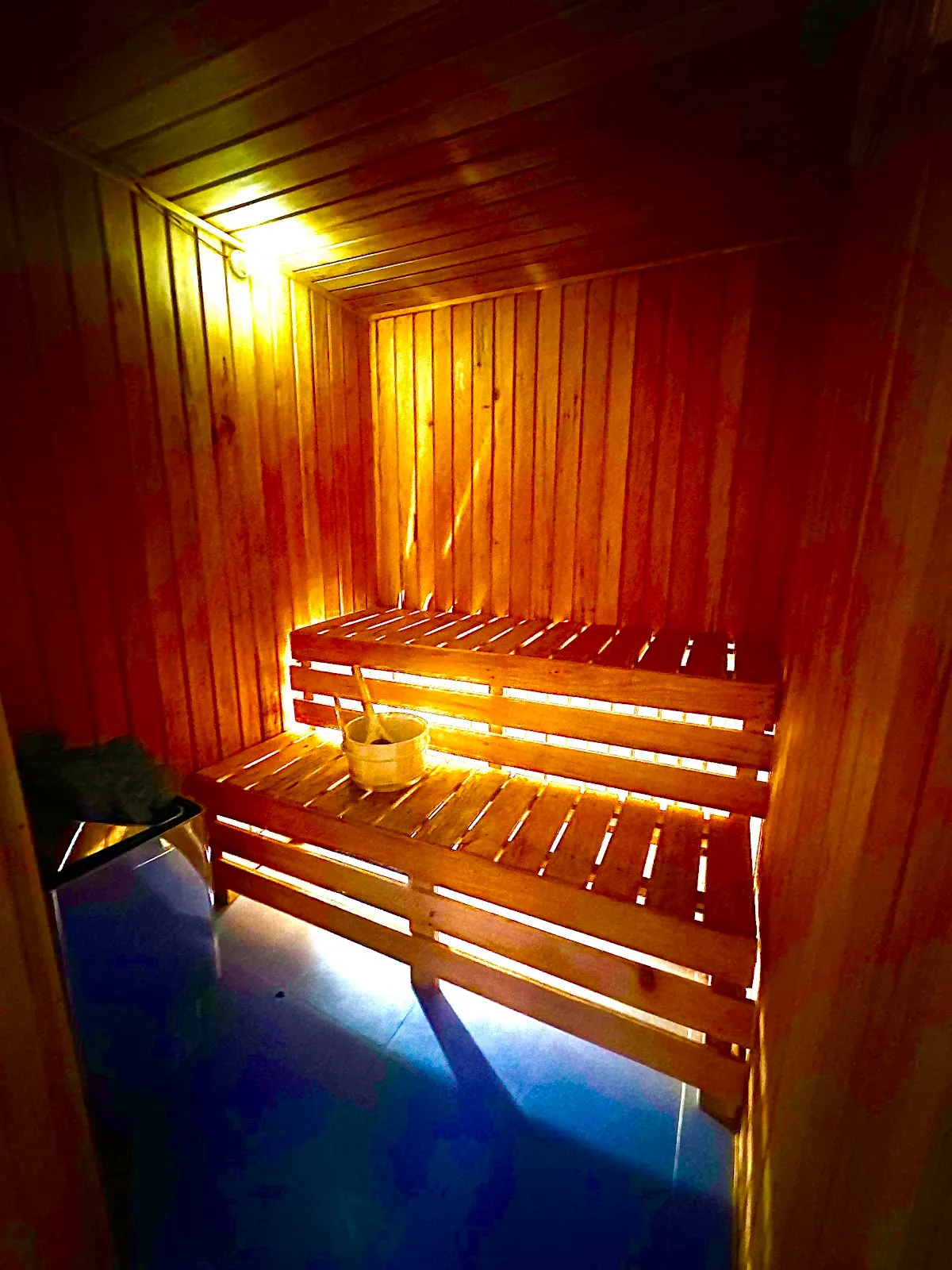 Wood sauna interior at Serenity Spa, glowing warm under low light.
